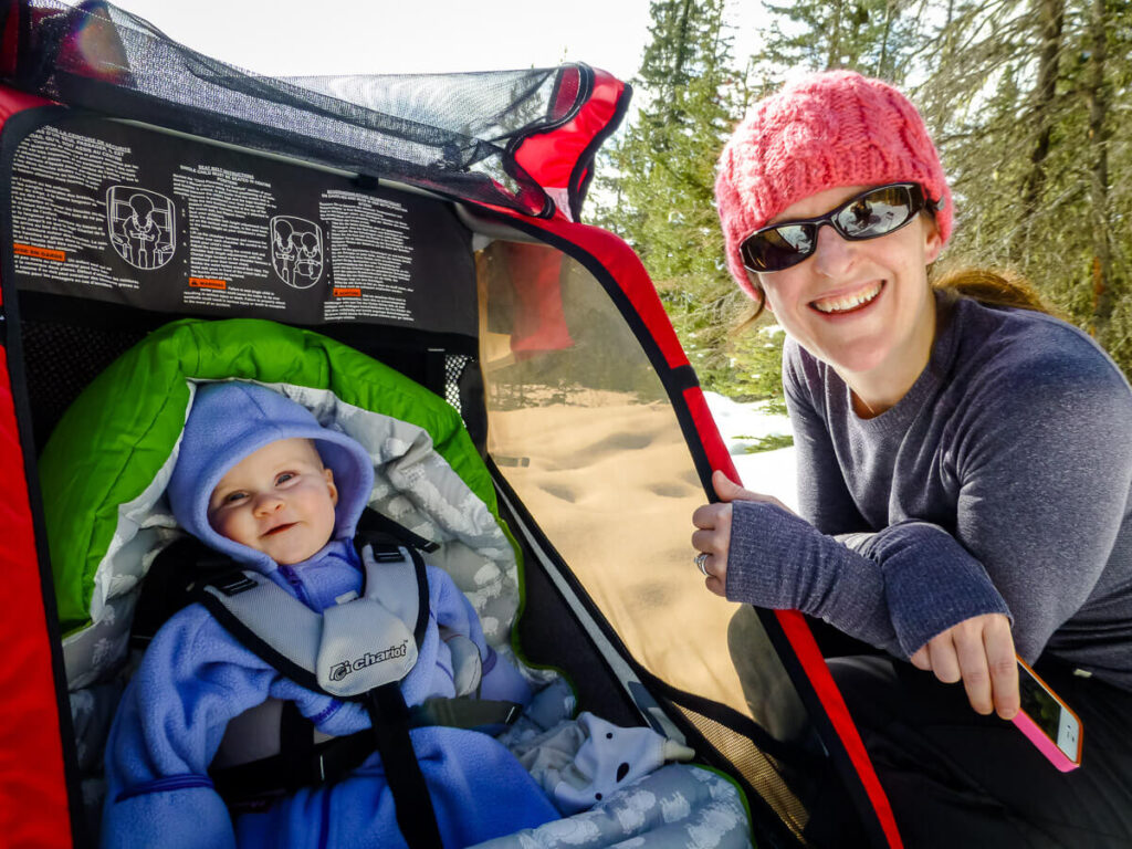 Celine Brewer, owner of Baby Can Travel, checks on her daughter while enjoying an outdoor winter activity in Canada.