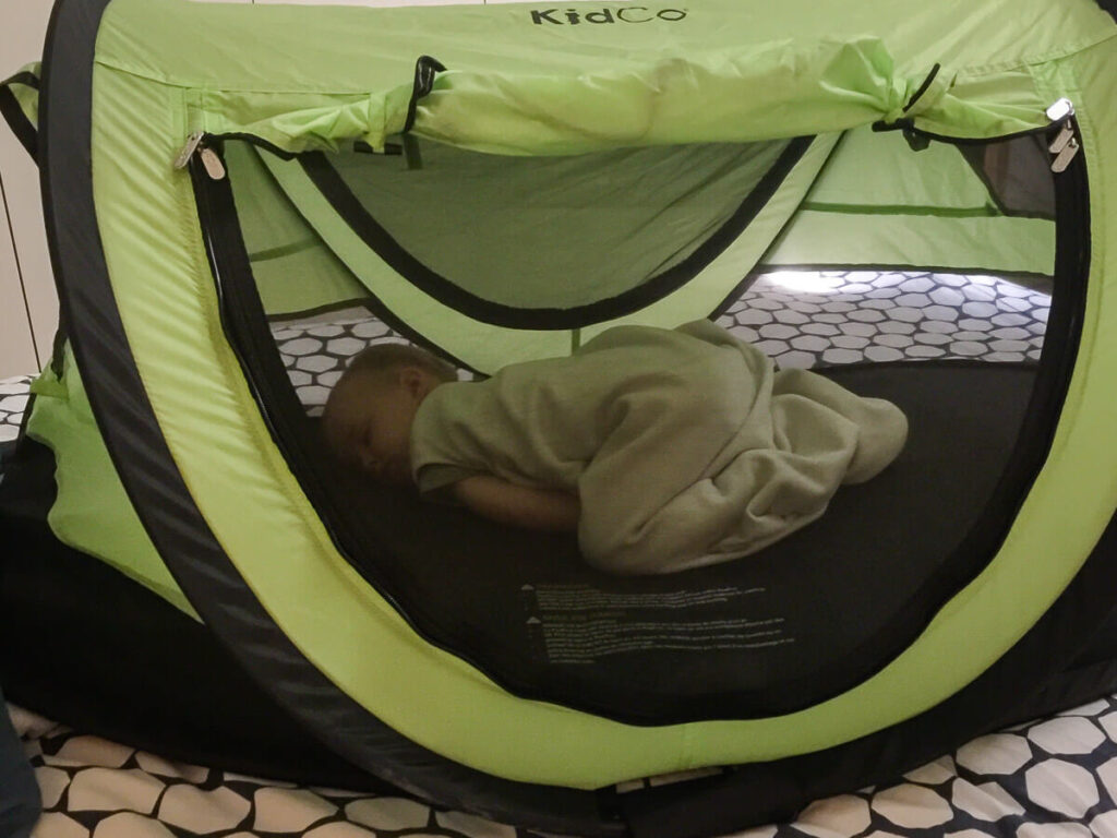 the KidCo PeaPod Plus portable travel bed fits in your luggage and is a nice alternative to flying with a pack n play or travel crib