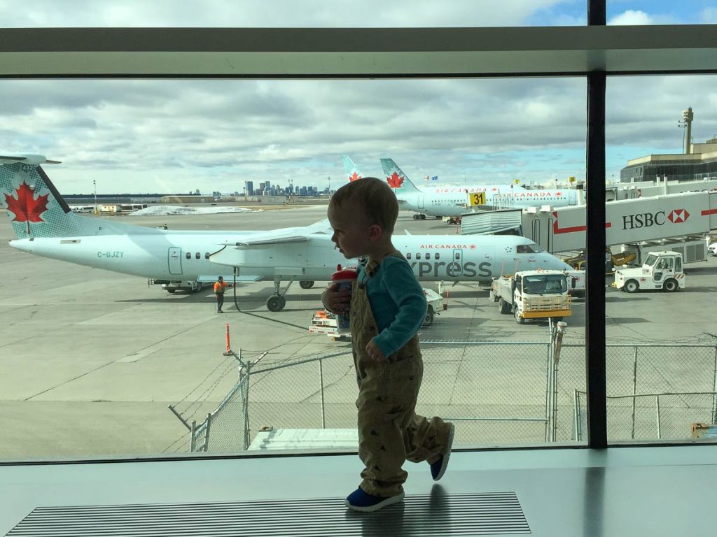 a toddler walks in an airport before an international flight.