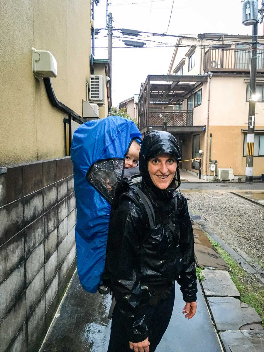 hiking in the rain with baby using backpack carrier with rain cover