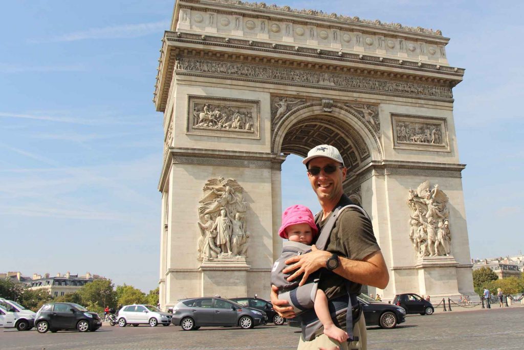 Dan Brewer, from BabyCanTravel.com, carries his 1 year old baby girl in an Ergobaby carrier while visiting the Arc de Triomphe on a family trip to Paris, France.