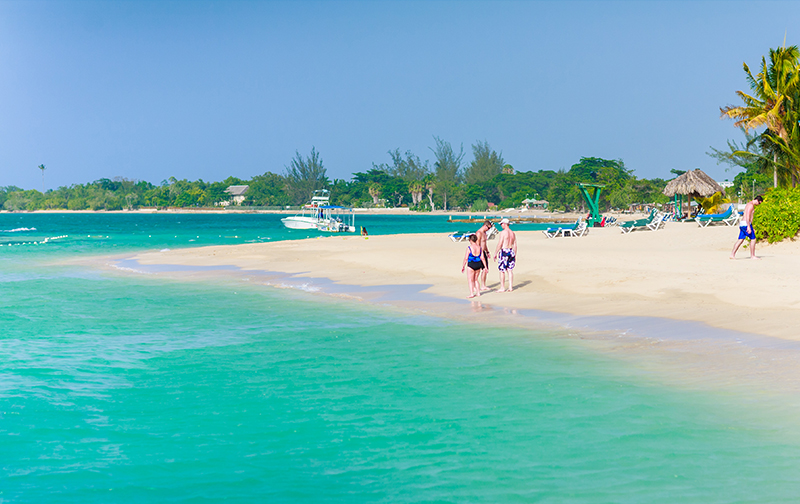 Guests walk by the turquoise Caribbean Sea in Jamaica at the Franklyn D. Resort & Spa  