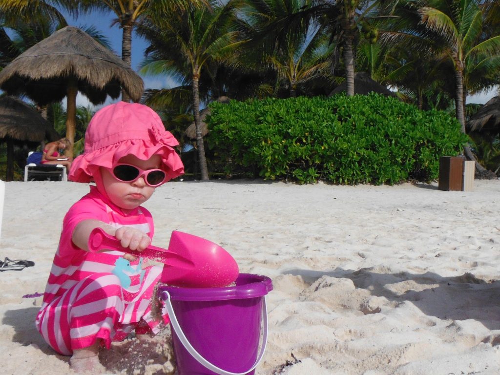 a child playing on the beach at a baby-friendly all-inclusive resort.