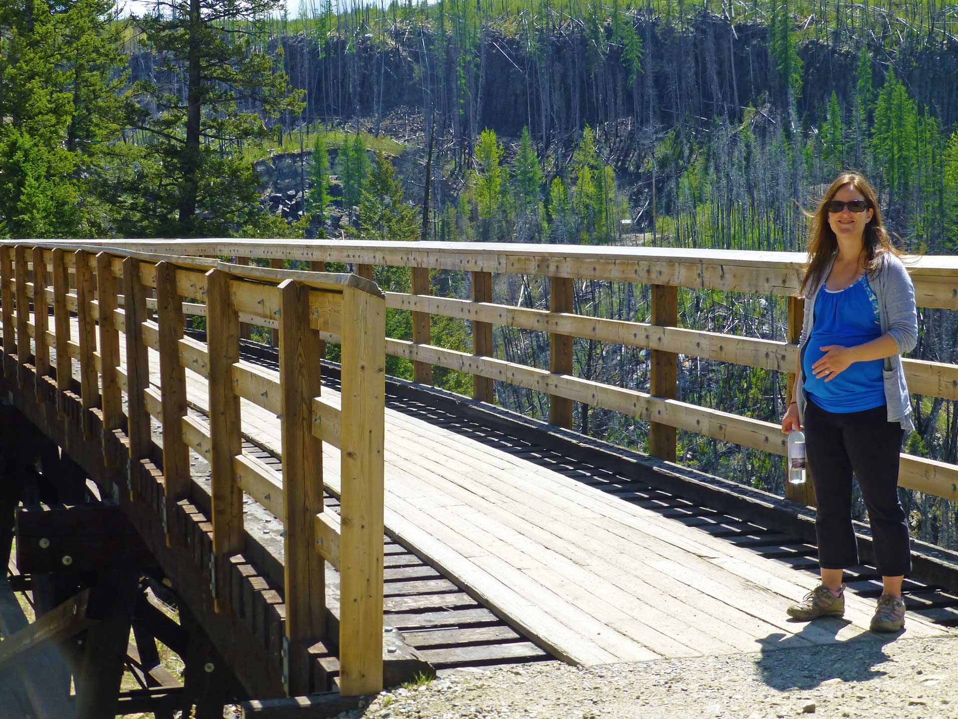 a pregnant woman on her babymoon enjoys the trestle hike in Kelowna, BC.