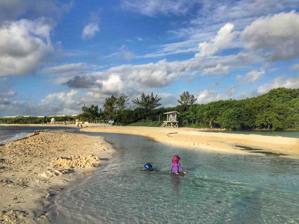 two kids play in a beachfront cenote while on a family trip to Playa del Carmen Mexico