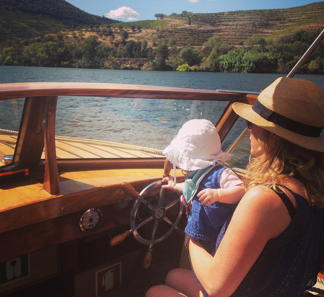 a mother enjoys a boat ride while traveling with her 8 month old baby.