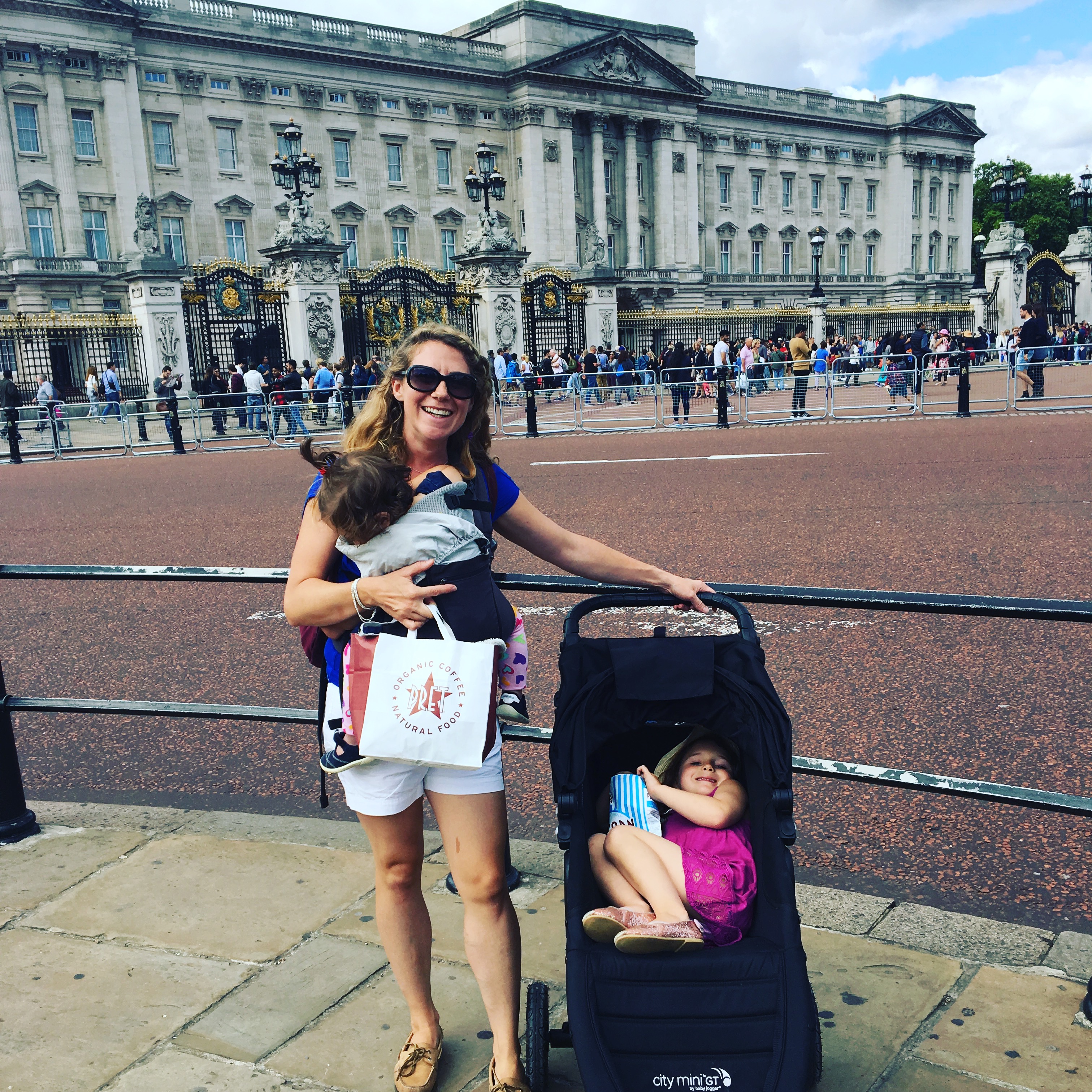 a mother traveling to London with a baby in a carrier and toddler in a stroller.