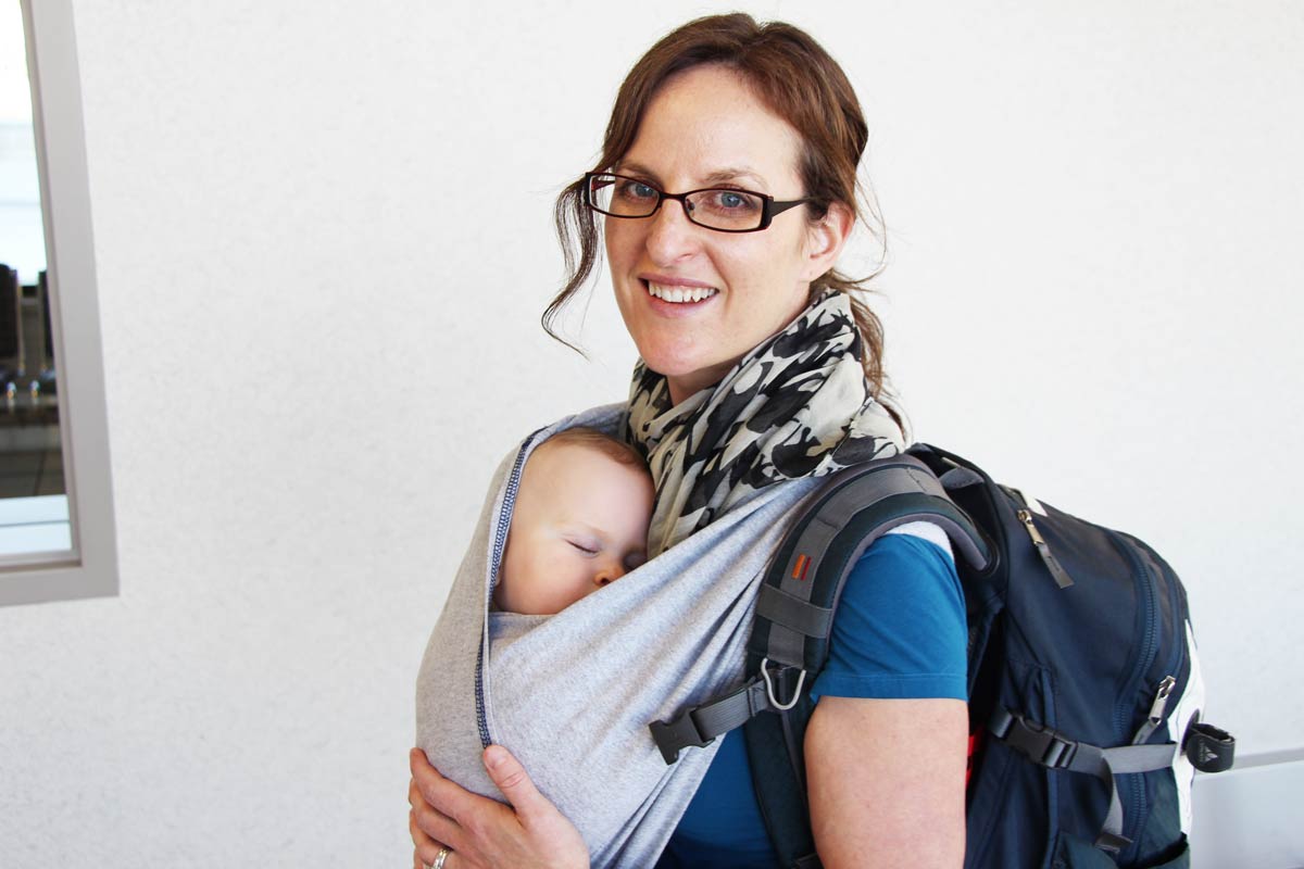 Celine Brewer, of BabyCanTravel.com, carries her baby in a Baby K'Tan carrier at the airport before a family flight.