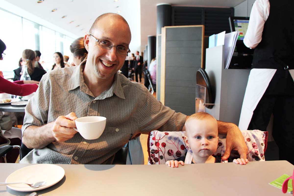 Dan Brewer, from Baby Can Travel, enjoys high tea in London while his baby sits nicely at the table in a travel high chair.