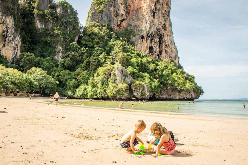 a toddler and his sister play in the sand on one of the many family friendly beaches in Thailand