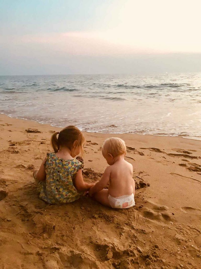 a baby and toddler play on the beach in Thailand while on a family holiday to Asia.
