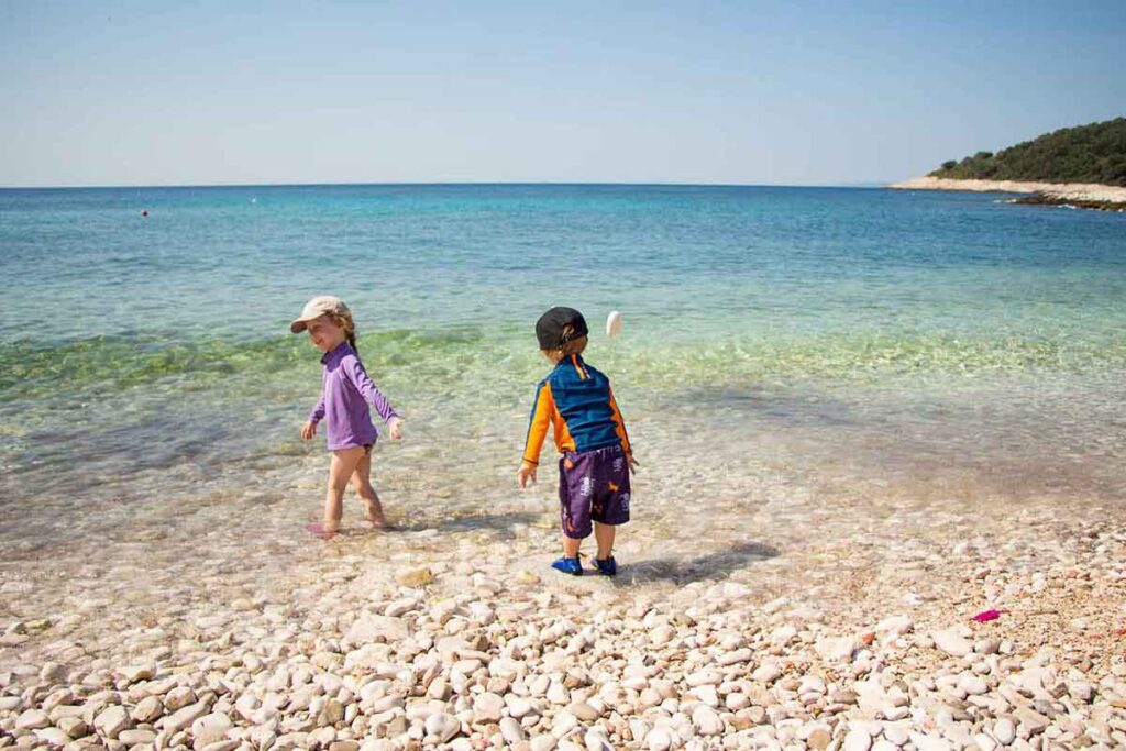 a toddler and preschooler play on a beach while on a family trip to Hvar, Croatia