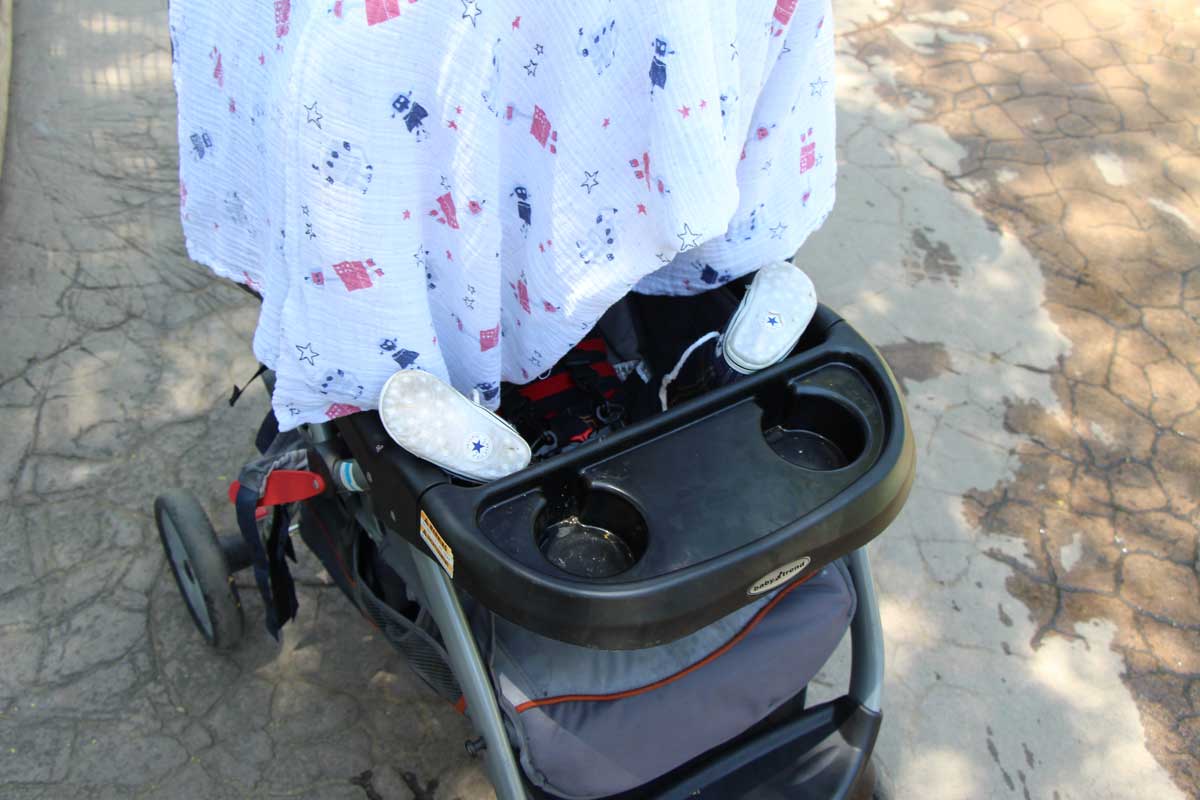 Celine Brewer uses a swaddle blanket as a sun shade on her baby stroller.