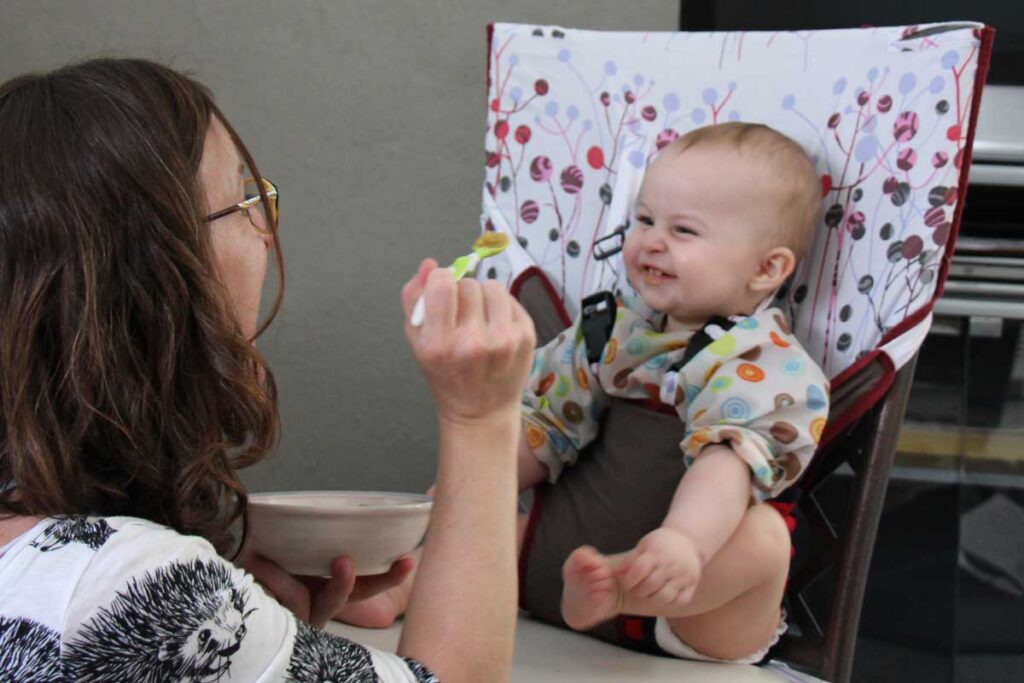 baby in portable travel high chair - one of the travel baby accessories