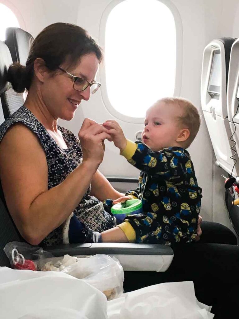 a mom entertaining her toddler on an international flight.