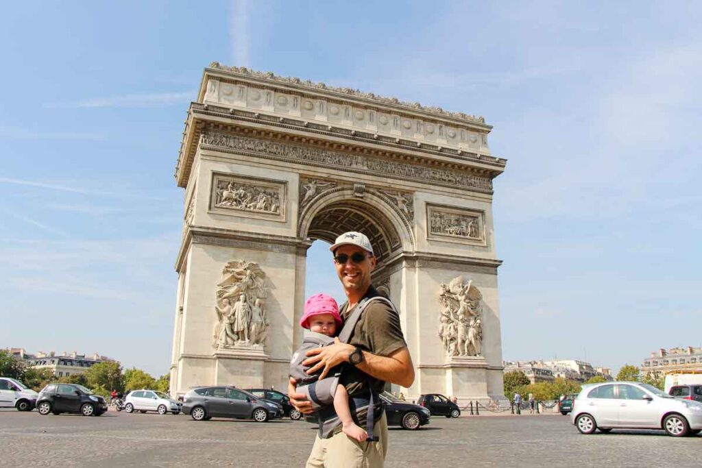 a Dad holds his baby while traveling in Paris