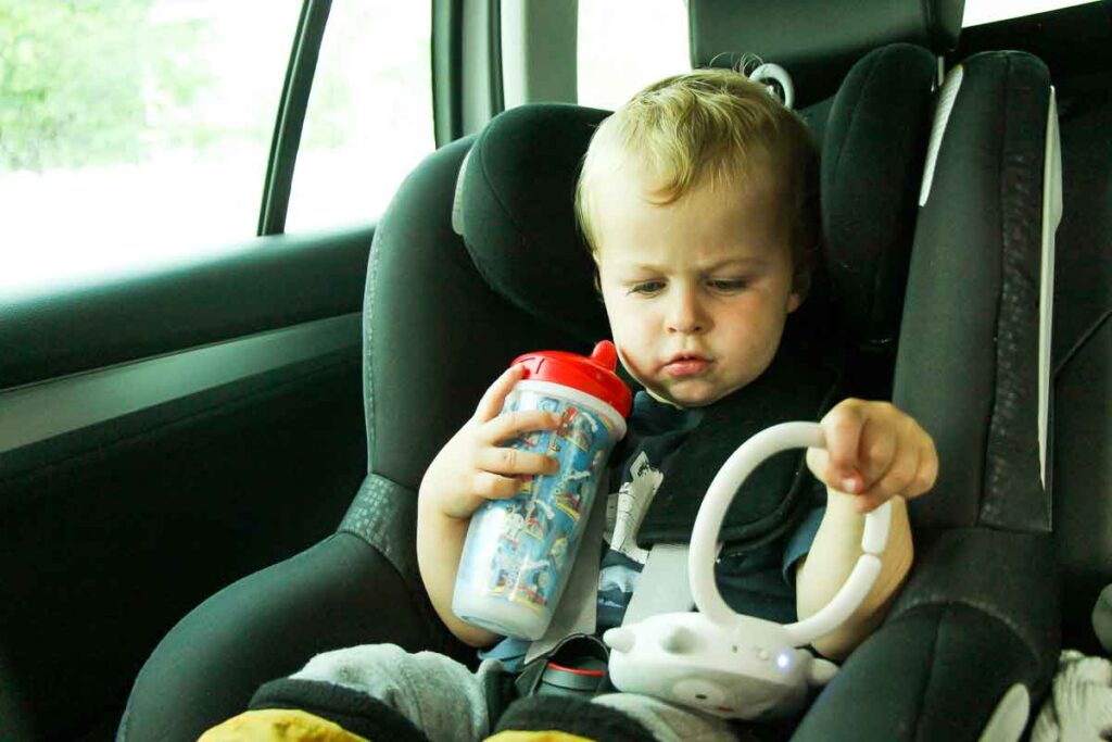 a toddler sits in a travel car seat
in a rental car on a family vacation