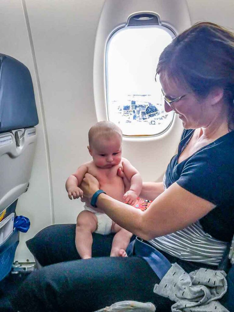 Celine Brewer flying with her infant in her lap.