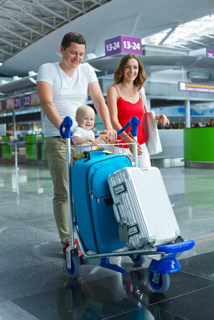 couple walking through airport with a baby