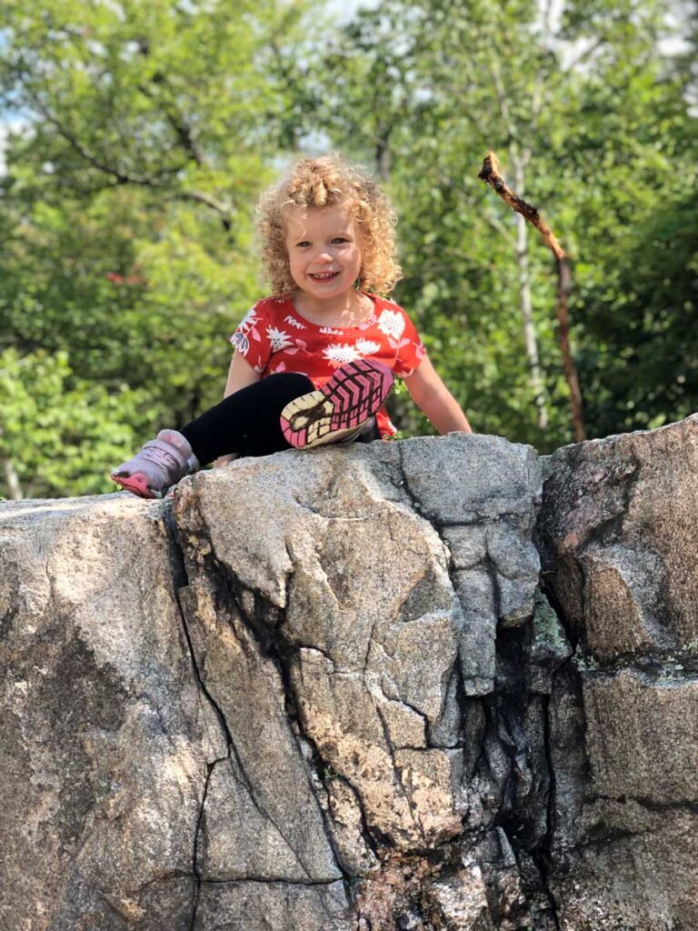 a toddler on rocks along Kancamagus scenic drive