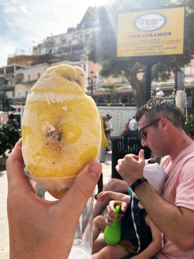 image of woman holding up lemon sorbet in Positano with baby or toddler