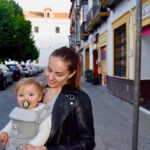 image of woman traveling with a baby in baby carrier