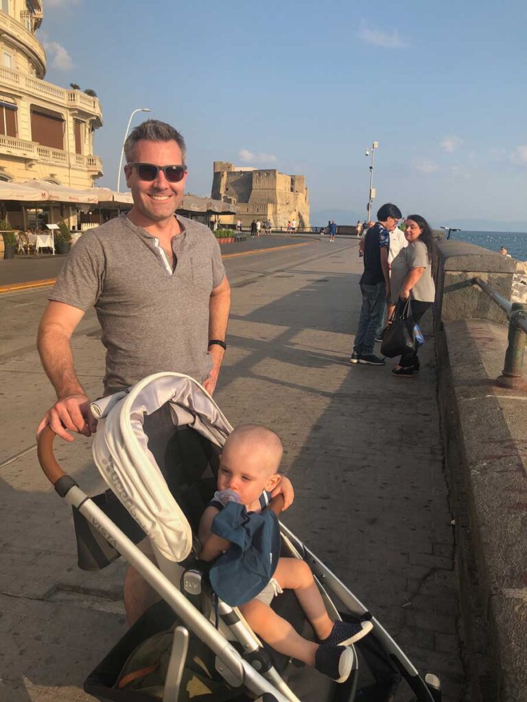 image of man pushing toddler in stroller in Italy