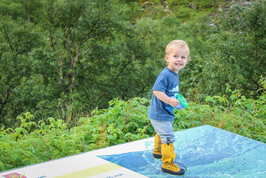 a Baby Can Travel toddler holds a snack cup on a family road trip in Europe.