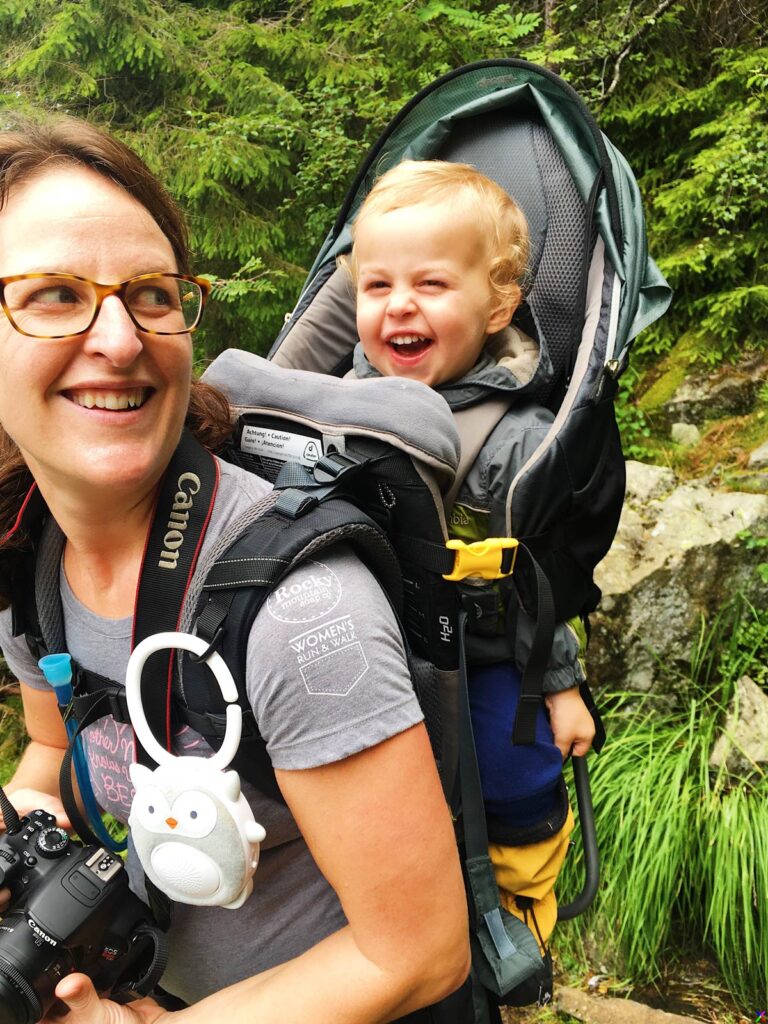 Celine Brewer and her toddler share a laugh while hiking with a Deuter Kid Comfort 3 backpack carrier.