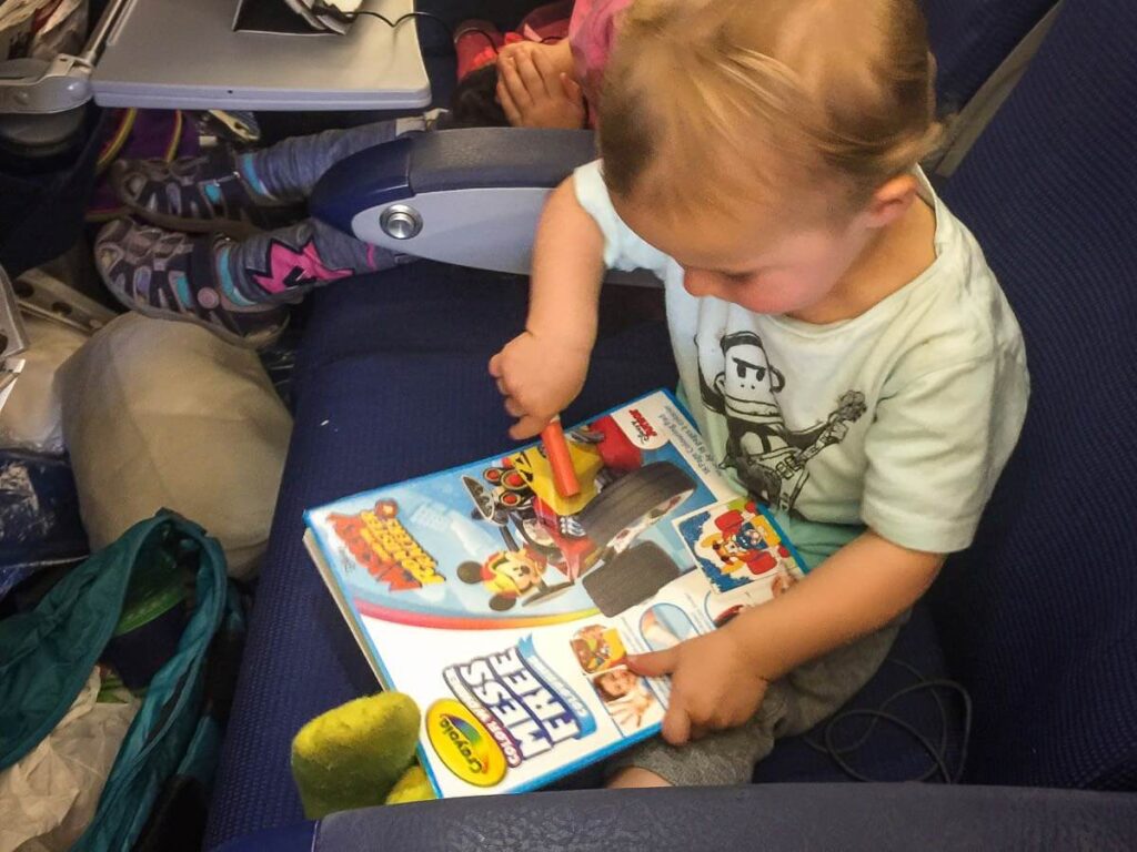 a toddler plays with a Crayola Color Wonder coloring book - one of the  best toddler travel toys for airplane.