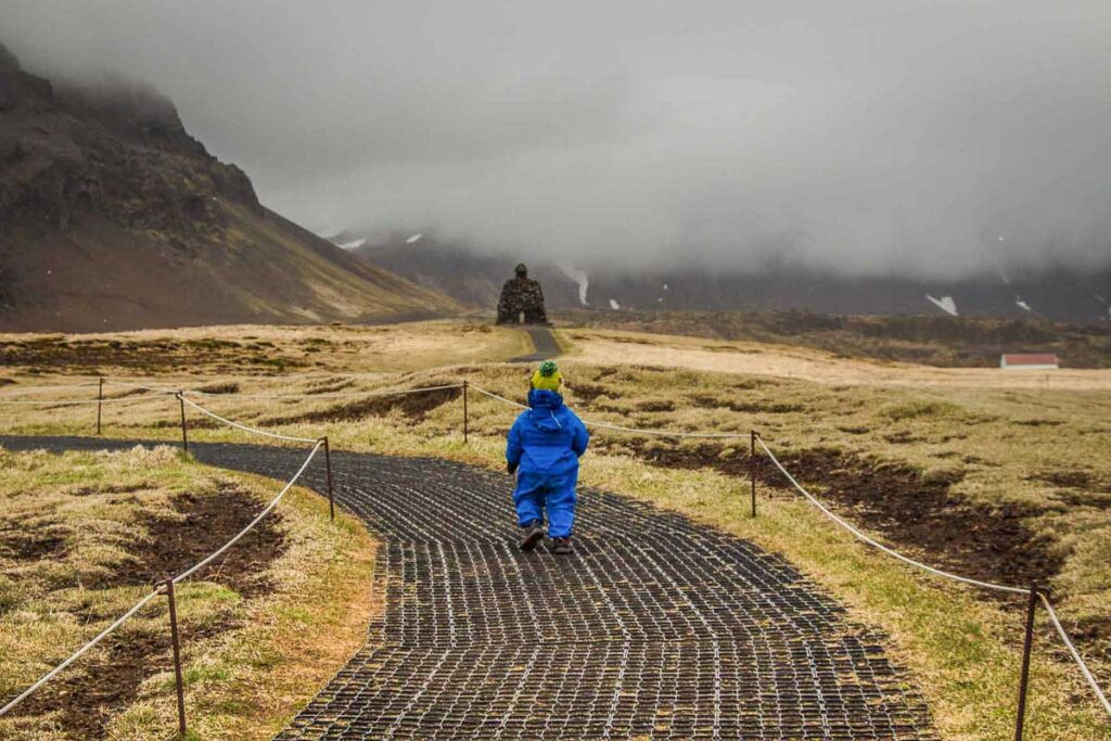 a warmly dressed toddler enjoys a hike during a family trip to Iceland