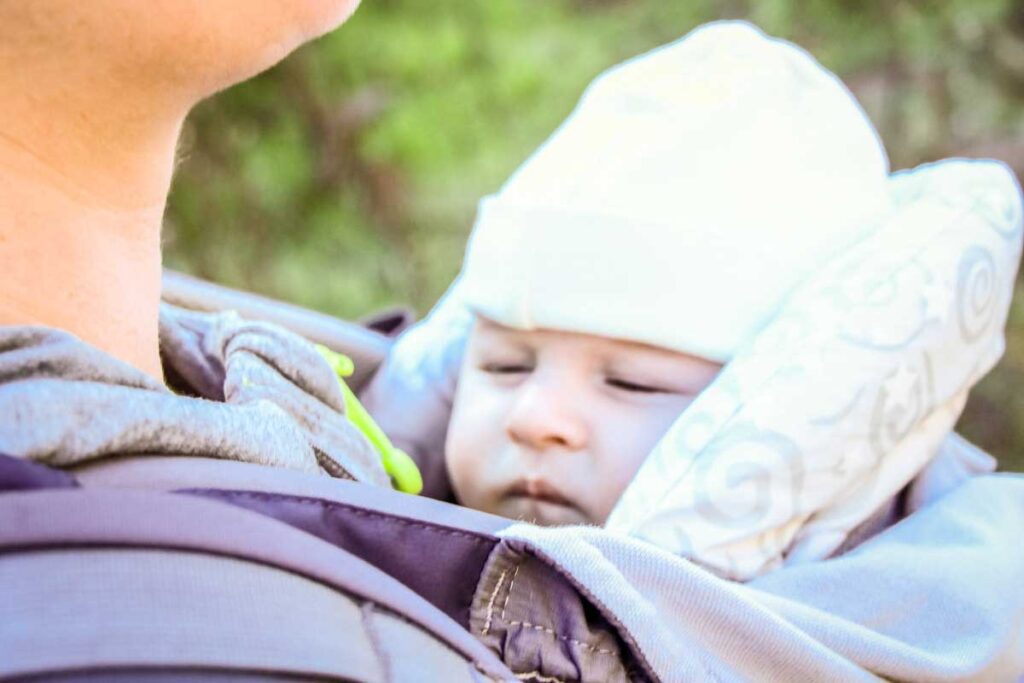 a mom is hiking with a newborn, who is asleep in his baby carrier