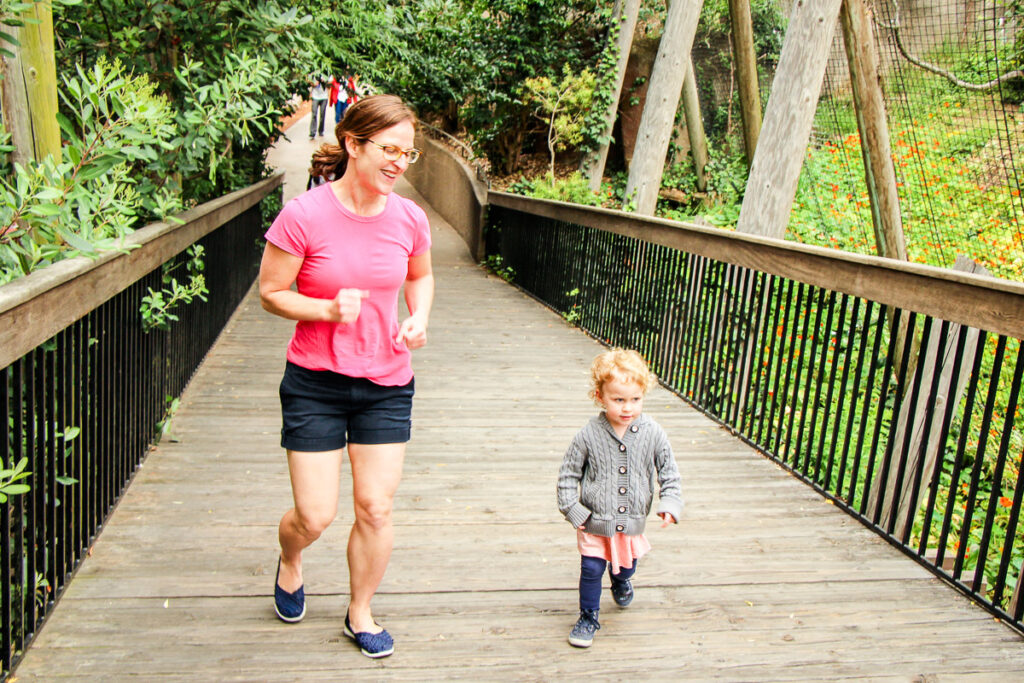 A mom and toddler have fun running to see new animals at the San Diego Zoo an on their family vacation to California.