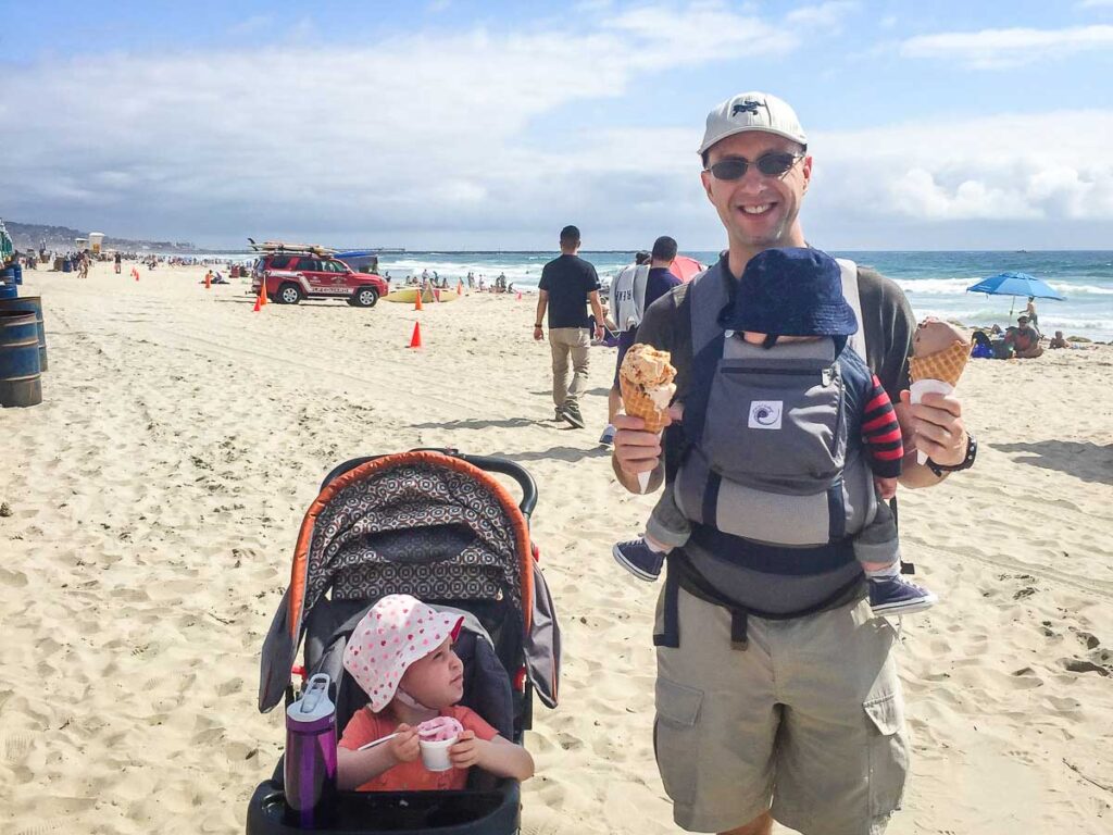 Dan Brewer, from BabyCanTravel.com, enjoys ice cream while carrying his son in an Ergobaby carrier on a family walk along the Mission Beach Boardwalk in San Diego, CA.