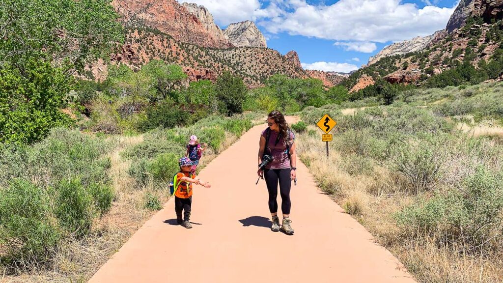 a toddler enjoys an easy walk on the Pa'rus trail while visiting Zion National Park with his family