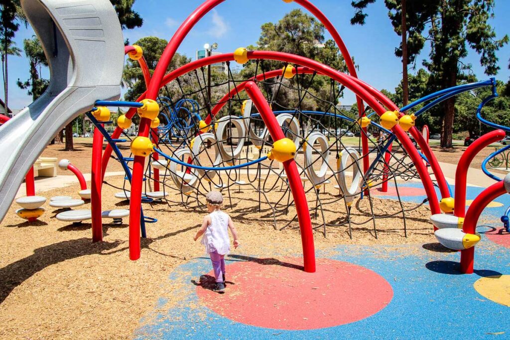 A toddler plays at the colorful sixth avenue playground in Balboa Park, San Diego, California.