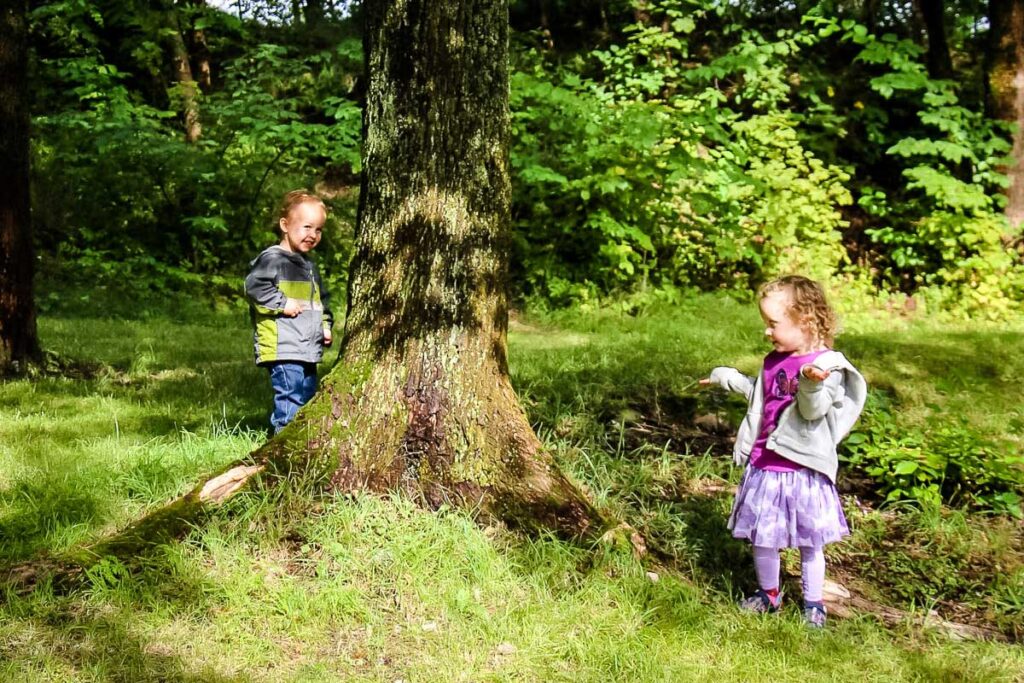 two kids play a game while out on a family hikes.