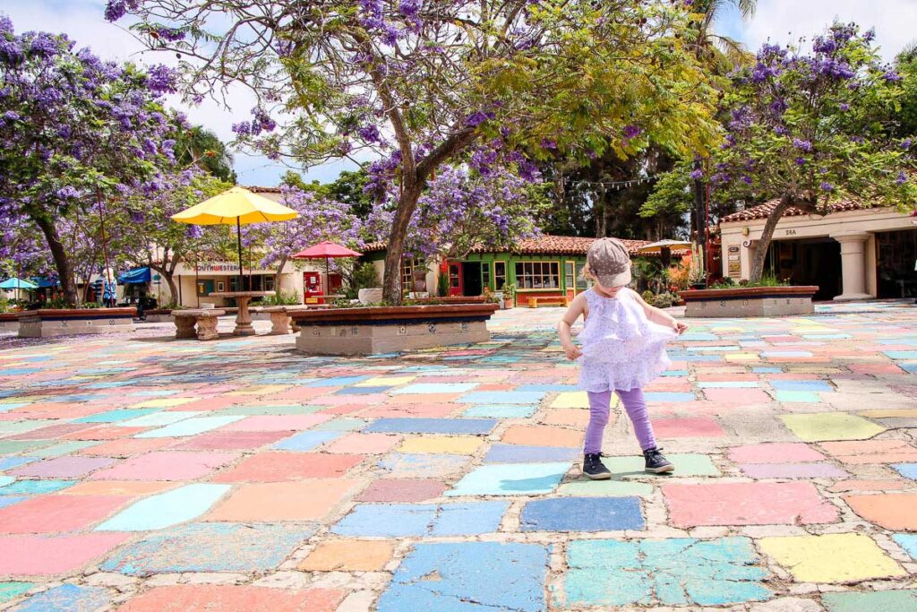 A toddler dances on the colorful tiles at the Spanish Village Art Center in Balboa Park, San Diego, CA.