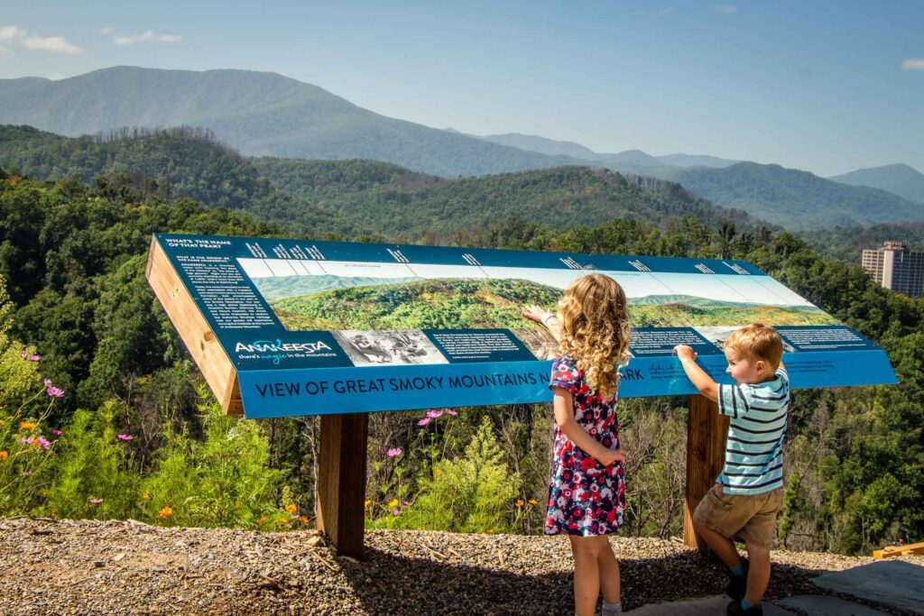 Two siblings read a sign while on a family trip to the Great Smoky Mountains National Park