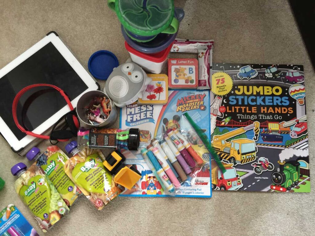 a photo of the snacks and screen-free toddler travel toys Celine Brewer (of BabyCanTravel.com) packs to entertain her children while traveling.