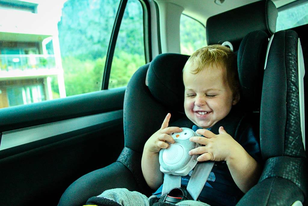 a toddler from the BabyCanTravel family uses a travel white noise machine while traveling with his family.