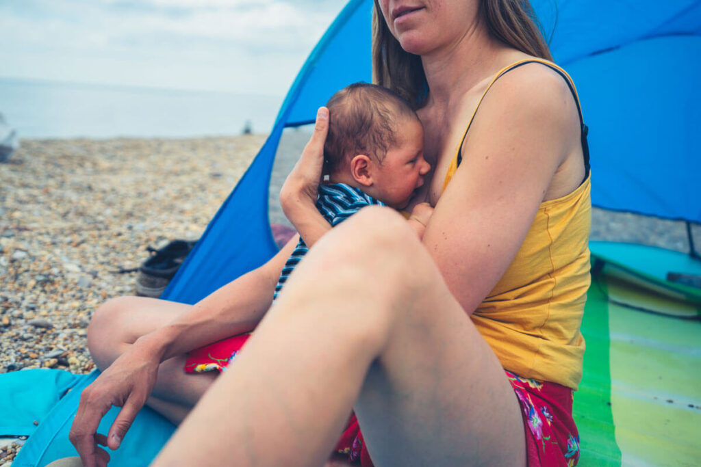 Mother and baby in baby beach tent on the beach