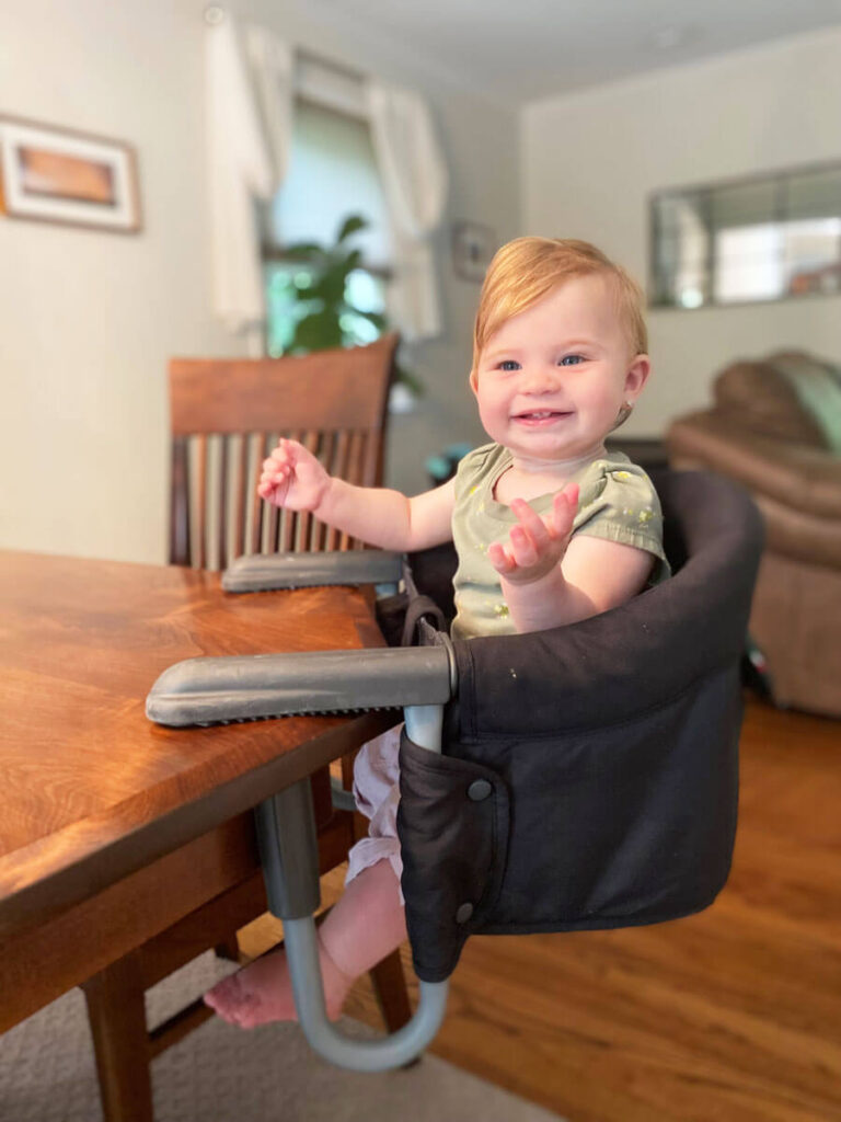 baby sitting in Inglesina high chair - baby seat that attaches to table