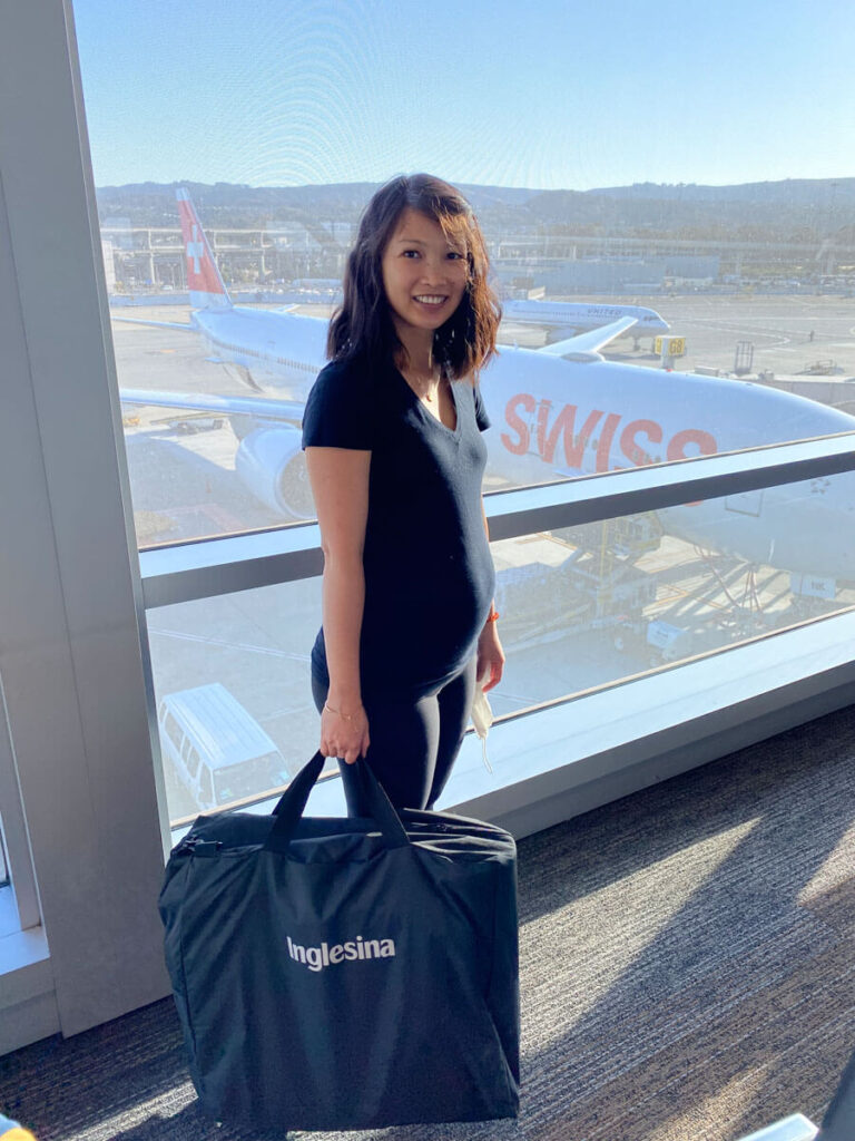 Inglesina Quid stroller that folds into a bag held by mother at airplane