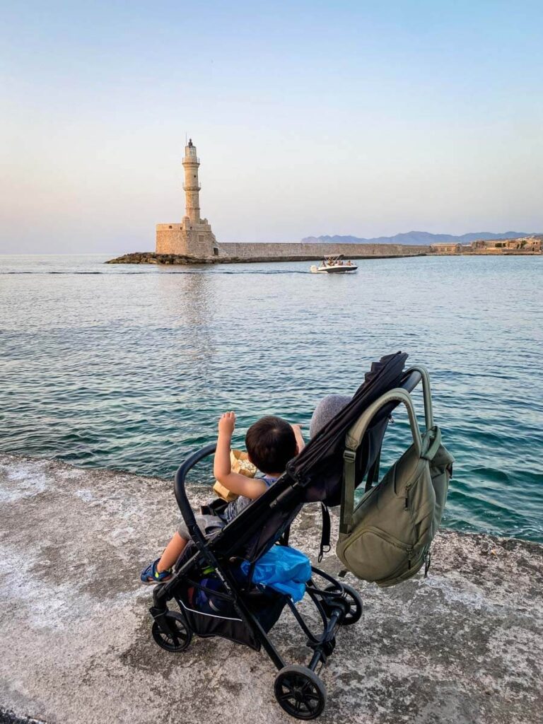 toddler in inglesina stroller in Crete overlooking ocean.