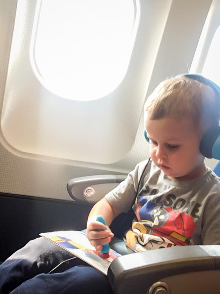 a toddler from the BabyCanTravel.com family listens to music with toddler headphones for airplane.