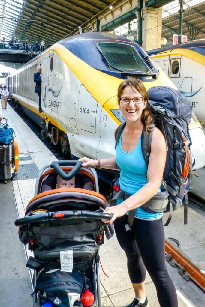 mother next to travel system with baby in car seat on stroller.