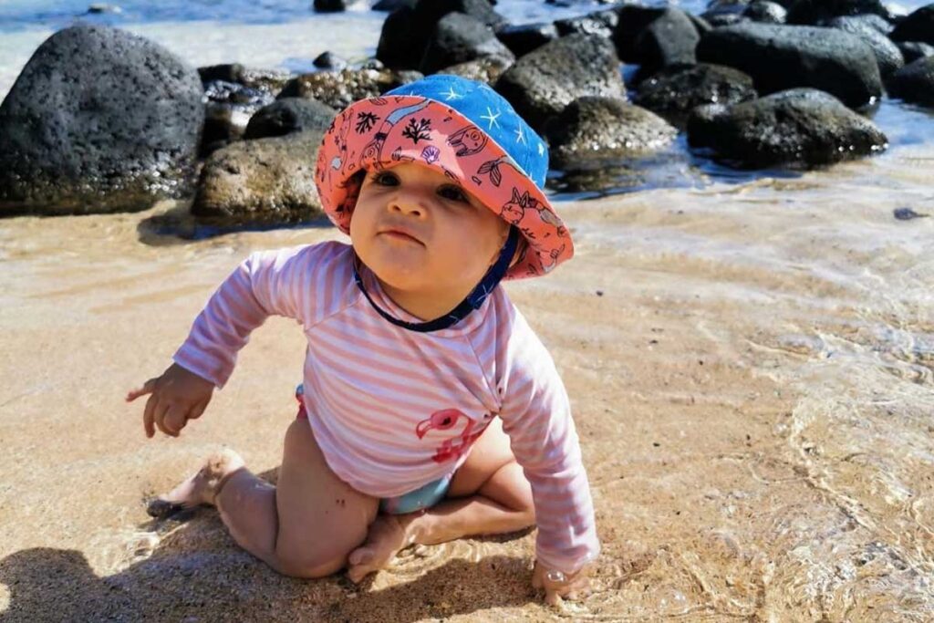 Baby at beach in sun hat