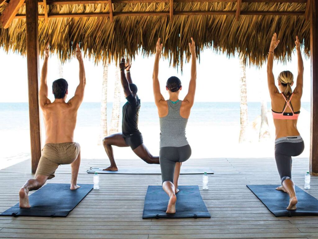 parents recharge and reconnect by doing oceanfront yoga at the at the Finest Playa Mujeres baby-friendly all-inclusive resort in Mexico.