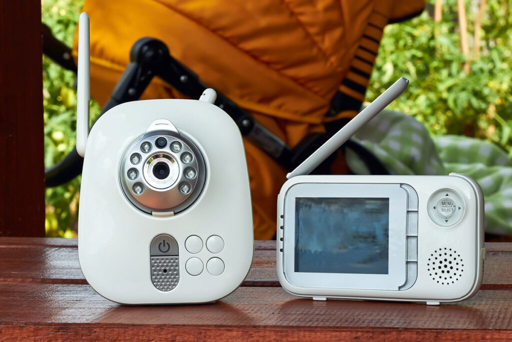 travel baby monitor outside on table with stroller in background.